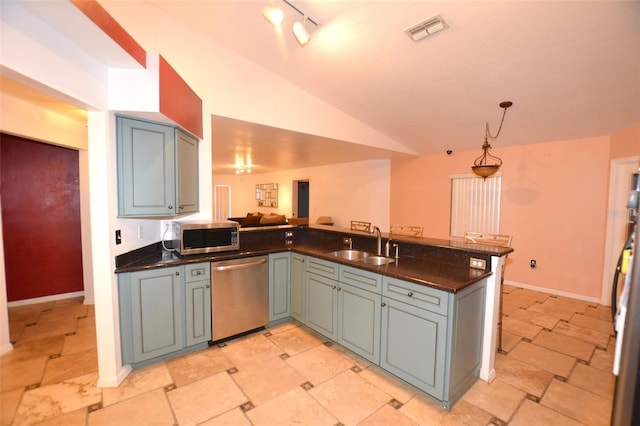 kitchen featuring kitchen peninsula, appliances with stainless steel finishes, gray cabinetry, sink, and lofted ceiling