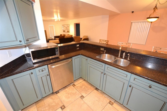 kitchen with dark stone counters, sink, pendant lighting, and appliances with stainless steel finishes