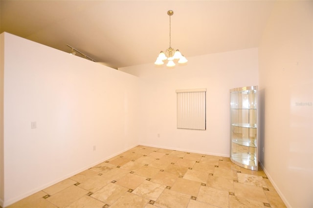 spare room featuring vaulted ceiling and a notable chandelier