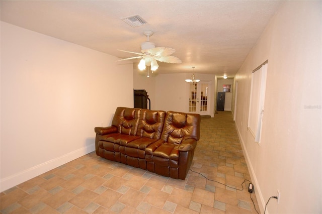 living room featuring french doors and ceiling fan with notable chandelier