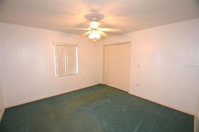 spare room with ceiling fan and dark carpet