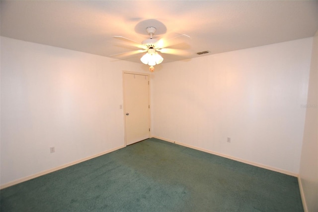 spare room with ceiling fan and dark carpet