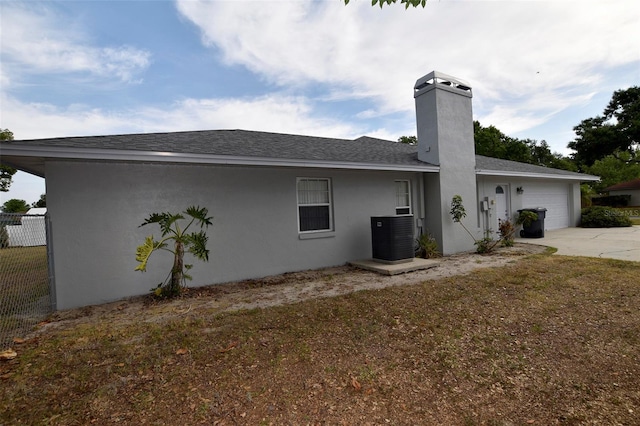 2556 Roslyn Ln, Lakeland, FL 33812 - back of property featuring central AC, driveway, fence, a garage, and stucco siding