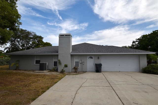 2556 Roslyn Ln, Lakeland, FL 33812 - view of front of house featuring concrete driveway, a chimney, a garage, stucco siding, and roof with shingles