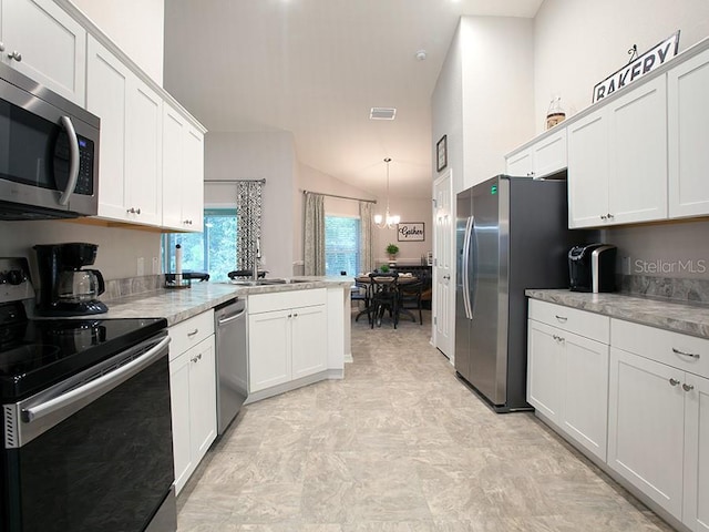 kitchen featuring lofted ceiling, sink, white cabinets, and appliances with stainless steel finishes