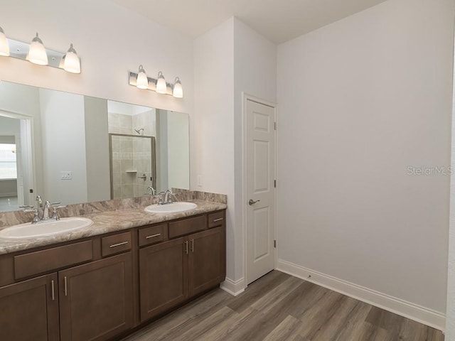 bathroom with walk in shower, wood-type flooring, and vanity