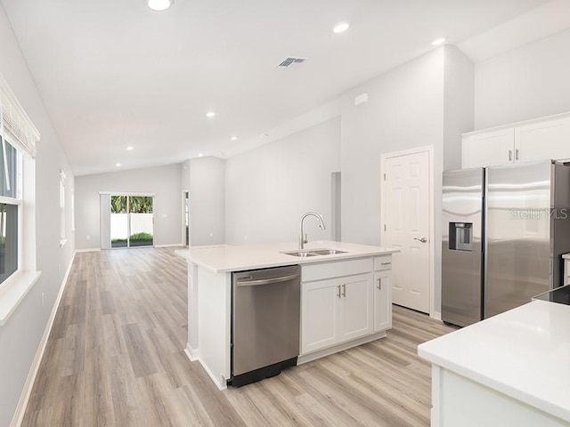 kitchen featuring white cabinetry, an island with sink, stainless steel appliances, sink, and vaulted ceiling