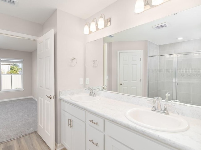 bathroom featuring wood-type flooring, vanity, and walk in shower