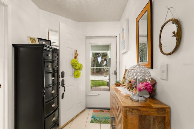 entryway featuring light tile patterned floors and a textured ceiling