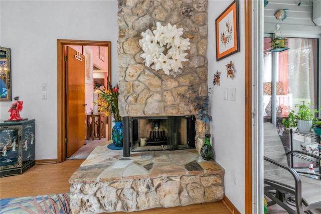 living room with hardwood / wood-style floors and a stone fireplace