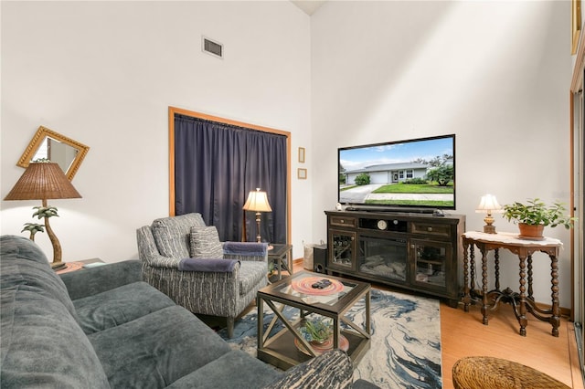 living room featuring hardwood / wood-style flooring and a towering ceiling