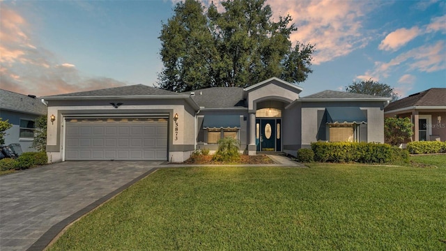 view of front facade featuring a garage and a lawn