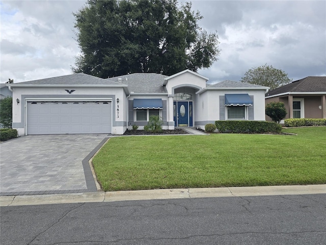 view of front of house with a garage and a front lawn