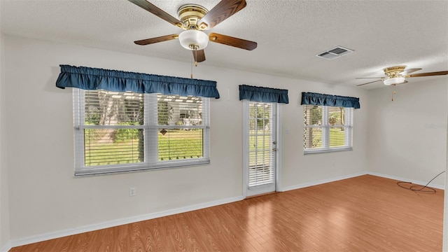 empty room featuring a textured ceiling and hardwood / wood-style flooring