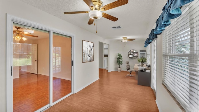 hallway featuring light wood-type flooring and a textured ceiling