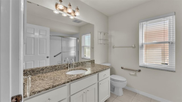 bathroom featuring tile patterned flooring, vanity, a healthy amount of sunlight, and a shower with door