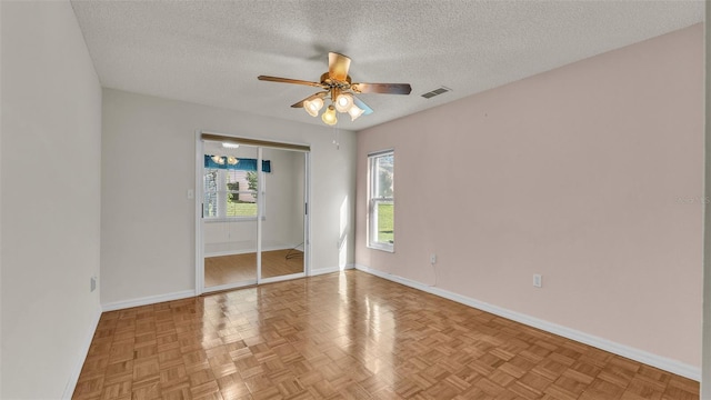 spare room featuring ceiling fan, parquet floors, and a textured ceiling