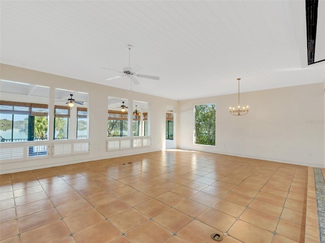 tiled spare room with an inviting chandelier