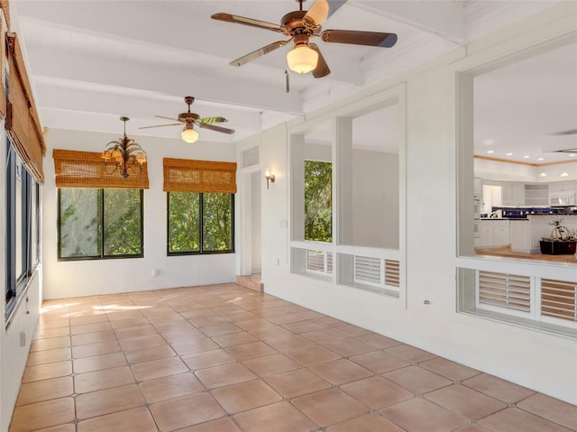 unfurnished sunroom featuring ceiling fan with notable chandelier and beam ceiling