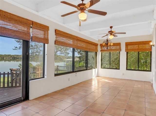 unfurnished sunroom with beam ceiling, a water view, and a healthy amount of sunlight