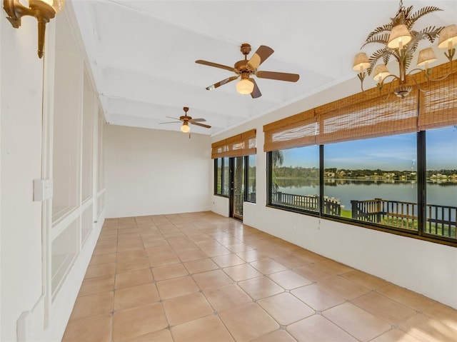 unfurnished sunroom with ceiling fan and a water view