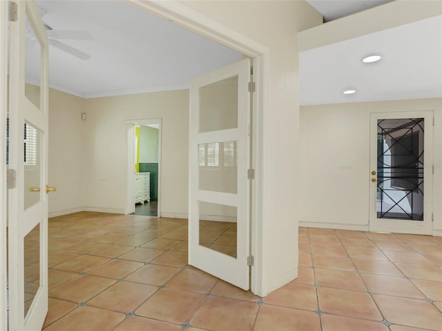 interior space with light tile patterned floors, french doors, and crown molding