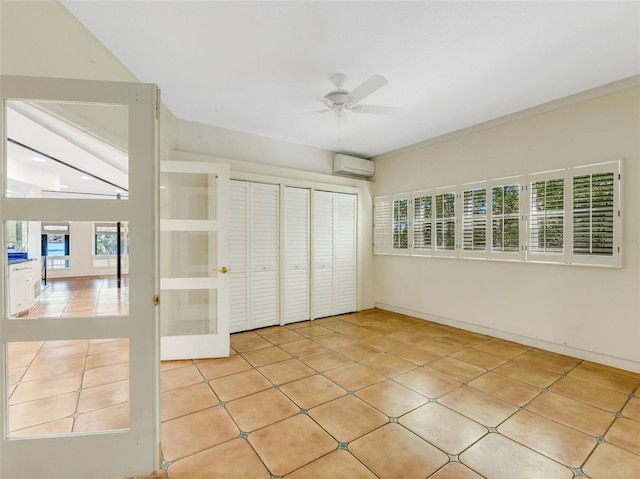 unfurnished bedroom with a wall unit AC, ceiling fan, a closet, and light tile patterned flooring