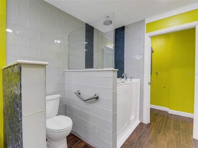 bathroom with a shower, hardwood / wood-style floors, toilet, and tile walls