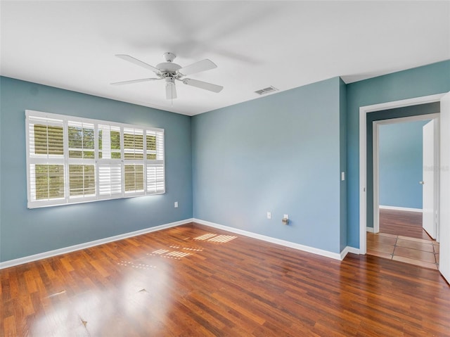 unfurnished room with ceiling fan and dark wood-type flooring