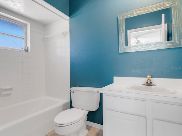 full bathroom with ceiling fan, vanity, tiled shower / bath combo, and toilet