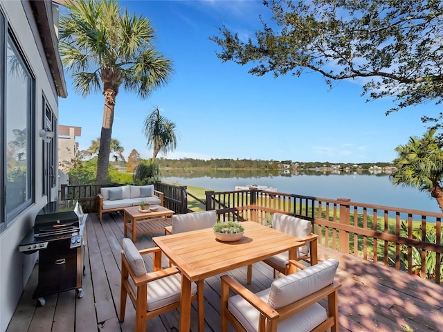 wooden deck with area for grilling, a water view, and an outdoor hangout area