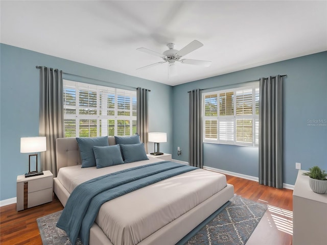 bedroom featuring dark hardwood / wood-style floors, multiple windows, and ceiling fan