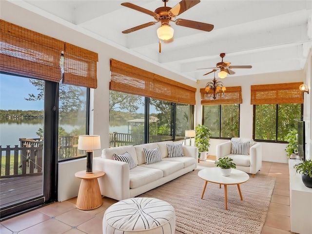 sunroom with beamed ceiling, a water view, a wealth of natural light, and ceiling fan