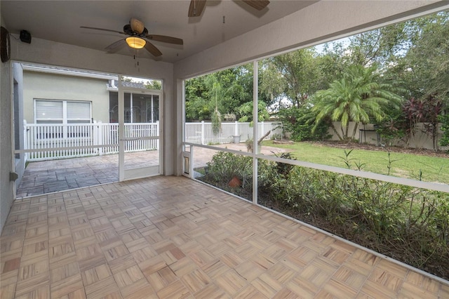 unfurnished sunroom featuring ceiling fan