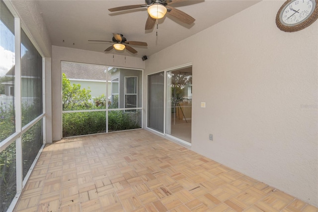 unfurnished sunroom with ceiling fan