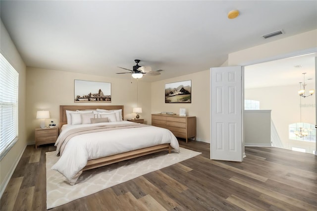 7018 Cascades Ct, Lakeland, FL 33813 - bedroom with a chandelier, wood finished floors, a ceiling fan, and baseboards