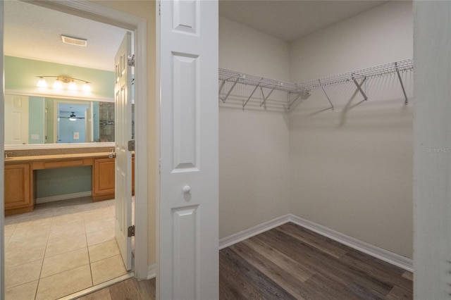 walk in closet featuring ceiling fan and light hardwood / wood-style flooring