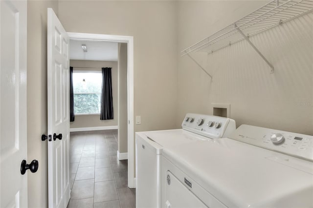 clothes washing area featuring washer and clothes dryer and light tile patterned flooring