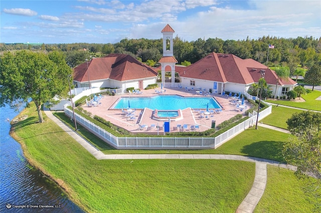 view of swimming pool featuring a lawn and a water view