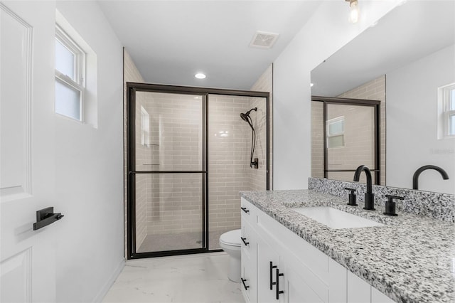 bathroom with a healthy amount of sunlight, toilet, and a shower with shower door