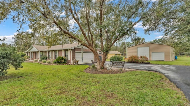 9240 Moore Rd, Lakeland, FL 33809 - view of front facade with a garage, a front lawn, driveway, brick siding, and an outbuilding