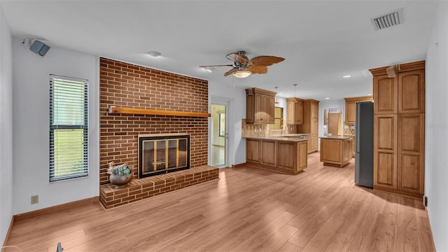 9240 Moore Rd, Lakeland, FL 33809 - unfurnished living room featuring a ceiling fan, light wood-style floors, baseboards, a brick fireplace, and recessed lighting