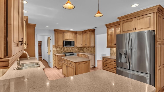 kitchen featuring sink, backsplash, pendant lighting, a kitchen island, and appliances with stainless steel finishes