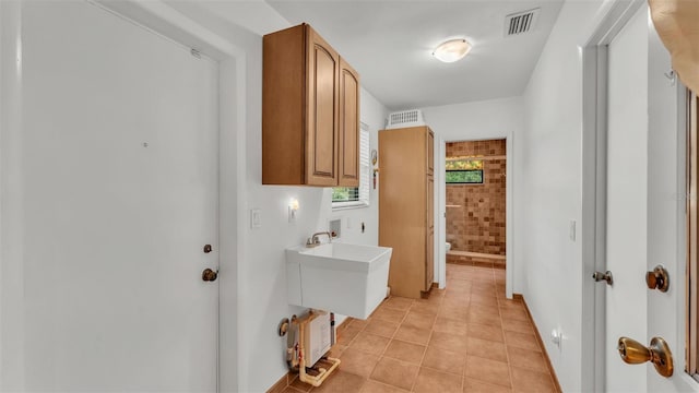 washroom with hookup for a washing machine, light tile patterned flooring, cabinets, and hookup for an electric dryer