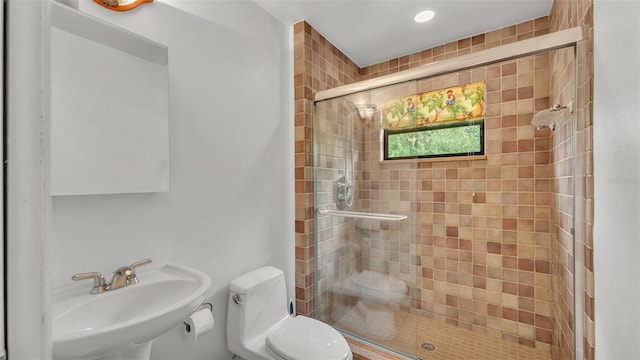 bathroom featuring sink, an enclosed shower, and toilet