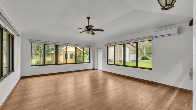 interior space with vaulted ceiling, an AC wall unit, and ceiling fan