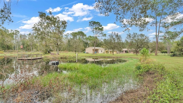 view of yard with a boat dock and a water view