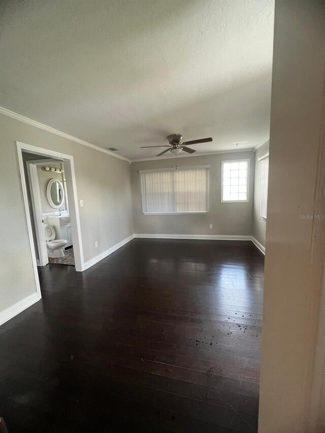 spare room featuring ornamental molding, a textured ceiling, ceiling fan, and dark wood-type flooring