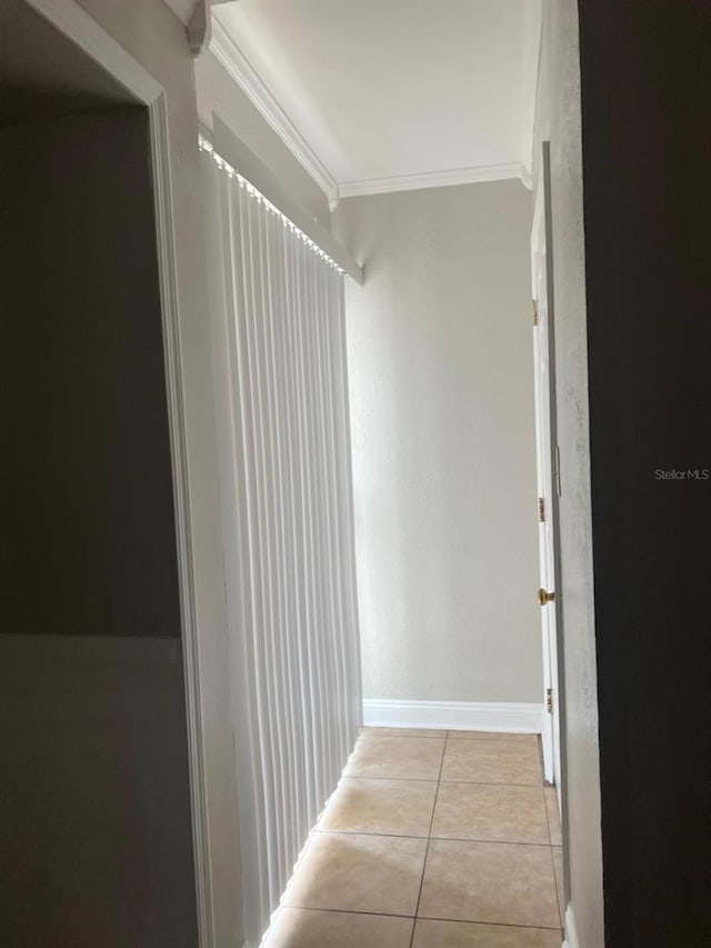 corridor featuring light tile patterned floors and ornamental molding