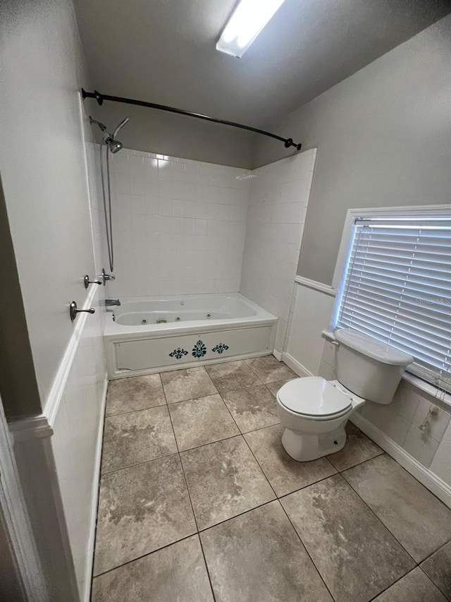 bathroom featuring tile patterned floors, toilet, and tiled shower / bath